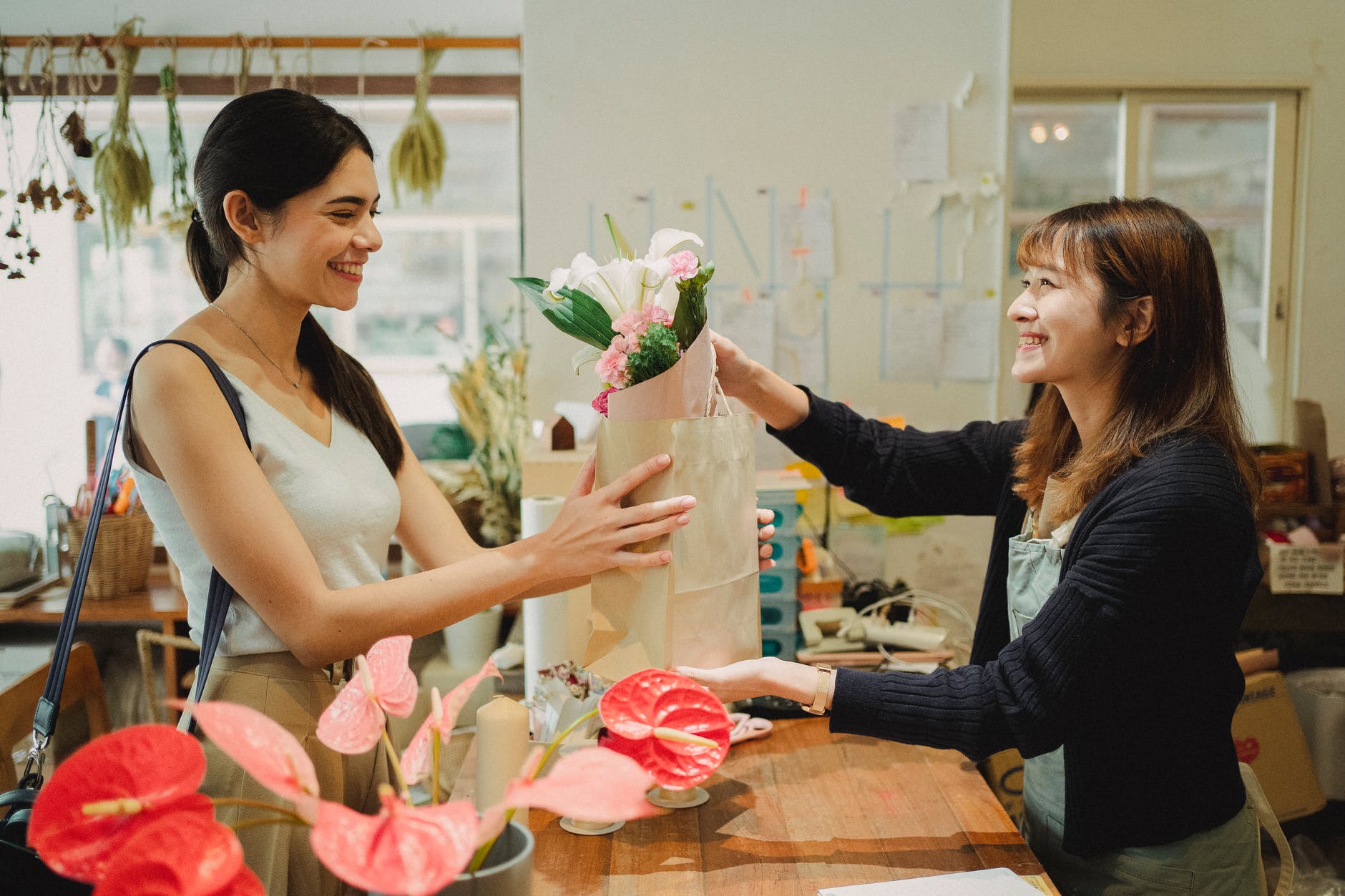 happy florist giving bouquet of flowers to lady