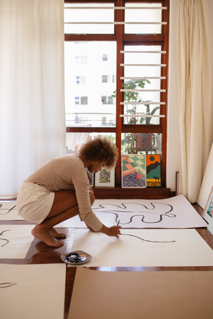 photo of woman drawing on white canvas; market without the sleaze