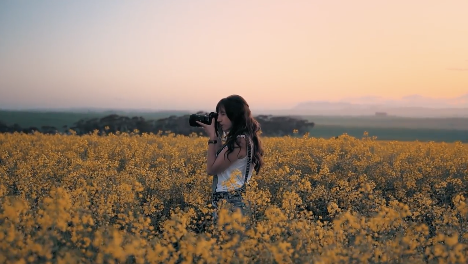 woman in field taking photographs